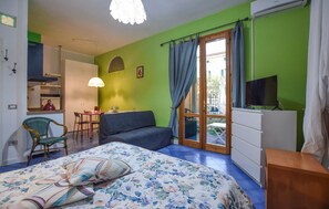Ein Zimmer mit einem Bett, einem Schlafsofa, einem Schreibtisch und einem Fernseher.