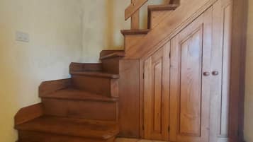 Una escalera de madera con barandilla que lleva a una puerta.