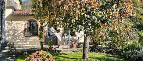 Una casa con jardín, un patio y una escalera que lleva a la entrada.