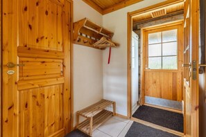 A wooden interior with a bench, a door, and a window.
