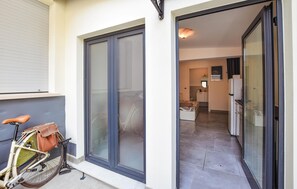 A residential entryway with a sliding glass door, a bicycle parked outside, and a glimpse into the interior featuring a kitchen and a dining area. - Cozy apartment in Chioggia with WiFi (Chioggia)