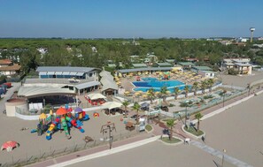 Ein Resort mit Swimmingpool, Kinderspielplatz und Strand.