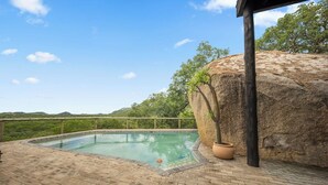 A swimming pool with a view of the landscape, a large rock, and a wooden structure. - Boulders Bush Lodge: A Private Boulder-Top Retreat in Greater Kruger (Mica)