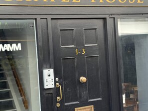 A black door with the number 1-3, a keypad, and a brass handle.