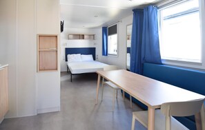 A compact hotel room with a single bed, a small table, and a chair. There is a window with curtains, a shelf unit, and a wall-mounted light fixture. - Amazing home in Torino di Sangro with swimming pool (Torino di Sangro)
