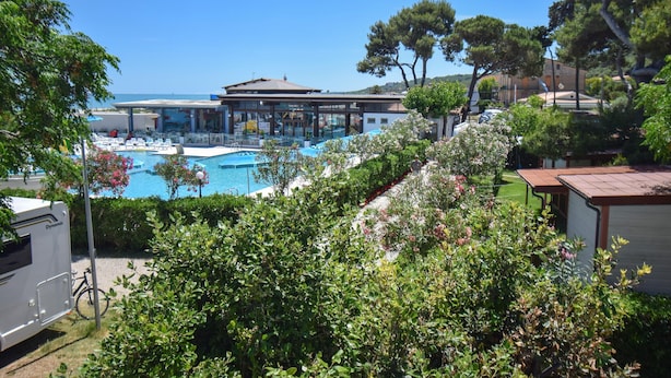 A pool area with a building in the background, surrounded by greenery and trees. - Awesome home in Torino di Sangro with WiFi (Torino di Sangro)