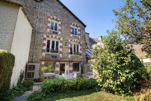 A two-story stone building with a balcony, a small garden, and a tree. - Bed and Breakfast 'La Prairie De Vassy 14 - Chausey' with Shared Terrace, Wi-Fi and Air Conditioning (Valdallière)