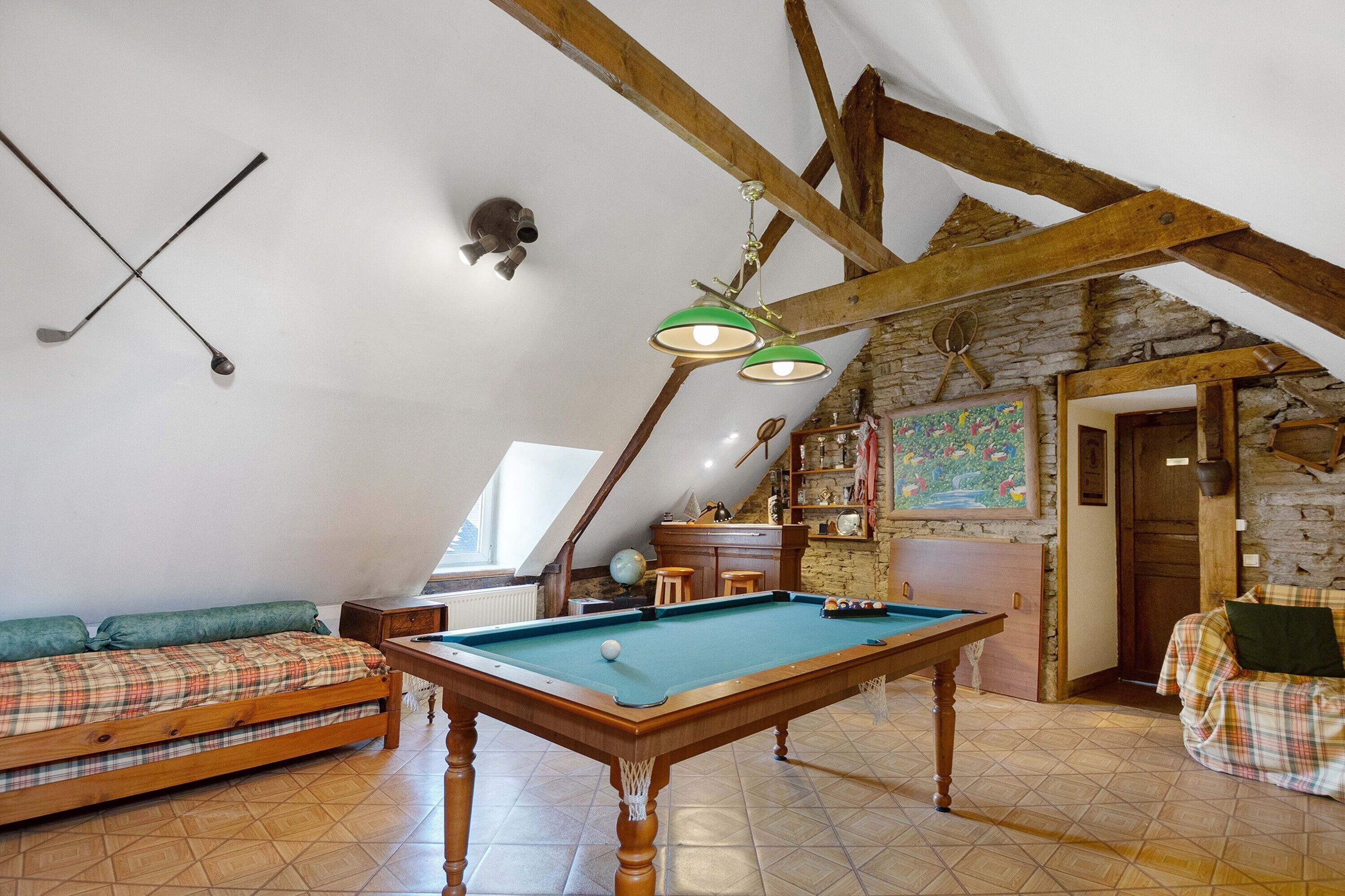 Une pièce confortable avec une table de billard, un canapé et un porte-taquets.