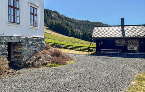 Ein Gebäude mit einer steinernen Fassade und einer Holzkonstruktion mit Ziegeldach.