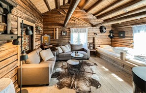 A log cabin interior with a sofa, a coffee table, and a fur rug. - Lovely home in Svatsum with house a mountain view (Svatsum)