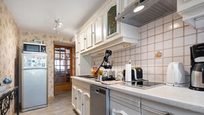 A kitchen with a refrigerator, microwave, coffee maker, and a dishwasher.