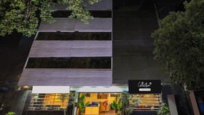 Um edifício moderno com fachada de vidro e placa indicando serviço de coleta corporativo.