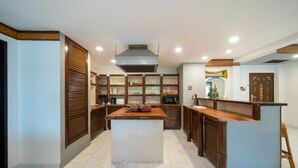Una cocina moderna con una isla central, armarios de madera y una estatua decorativa.