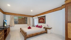 Un dormitorio con una cama de madera, un televisor y un ventanal con cortinas.