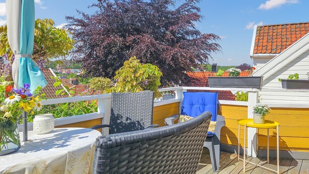 A balcony with wicker furniture, a small table, and a chair.