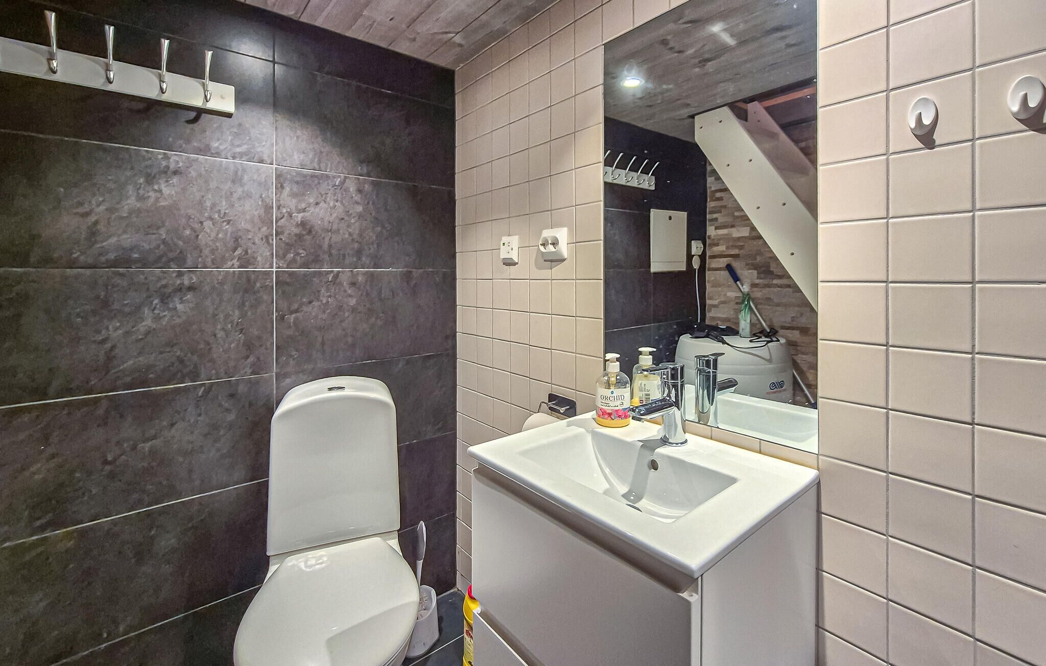 Une salle de bain moderne avec des toilettes, un lavabo et un miroir.