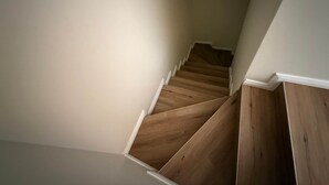 A staircase with wooden steps and white walls. - Your Beach Escape Starts Here (Wannanup)