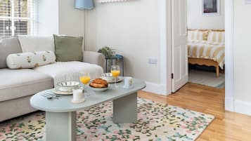 Una sala acogedora con sofá, mesa de centro y espacio para desayunar.