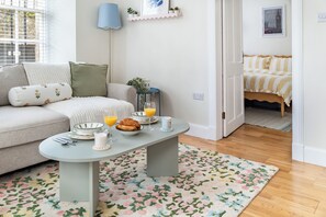Uma sala de estar aconchegante com um sofá, uma mesa de centro e espaço para café da manhã.