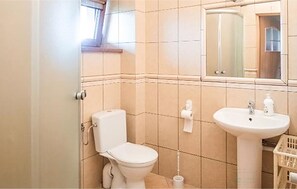 Un baño con inodoro, lavamanos y espejo.