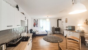 Ein gemütlicher Wohnbereich mit Küchenzeile, einem Bett, einem Fernseher und einer Essecke.