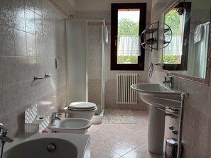 Ein Badezimmer mit Dusche, Toilette, Bidet, Waschbecken und Badewanne.