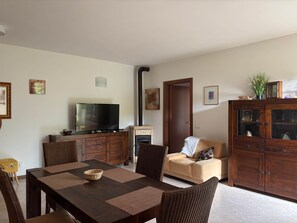 Ein Wohnzimmer mit Fernseher, Kamin, Sofa und Holzausbau.