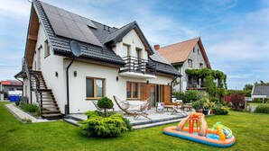 A two-story house with a balcony, a small garden, and an inflatable pool. - Gorgeous apartment in Nowecin with WiFi (Nowecin)