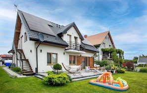 A two-story house with a balcony, a small garden, and an inflatable pool. - Gorgeous apartment in Nowecin with WiFi (Nowecin)