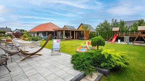 A residential area with a house, a covered patio, and a playground with a slide. - Gorgeous apartment in Nowecin with WiFi (Nowecin)