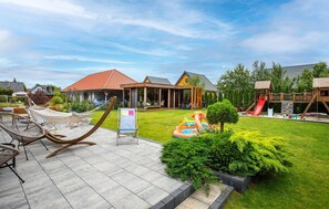 A residential area with a house, a covered patio, and a playground with a slide. - Gorgeous apartment in Nowecin with WiFi (Nowecin)