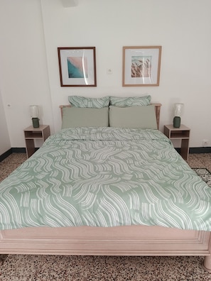 A bedroom with a bed, two nightstands, a headboard, and two framed pictures on the wall. - Charmante maison familiale de 3 chambres (Champignelles)