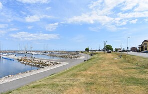 A marina with boats, a grassy area, and buildings in the background. - Stunning home in Borrby (Borrby)