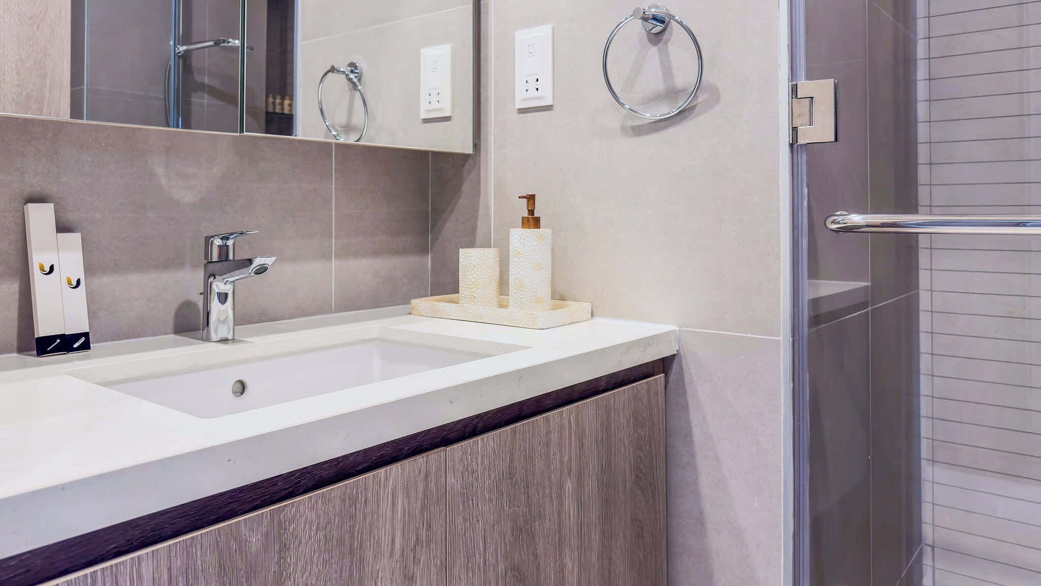 Un baño moderno con tocador de doble lavabo, espejo y cabina de ducha de vidrio.