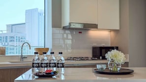 A modern kitchen with a large window, a stainless steel range hood, and a view of the cityscape. - Luxury 2BR Plus Maids, High-Floor Marina Views (Dubai)