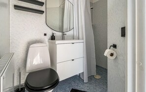 Ein modernes Badezimmer mit Toilette, Waschbecken und Dusche.
