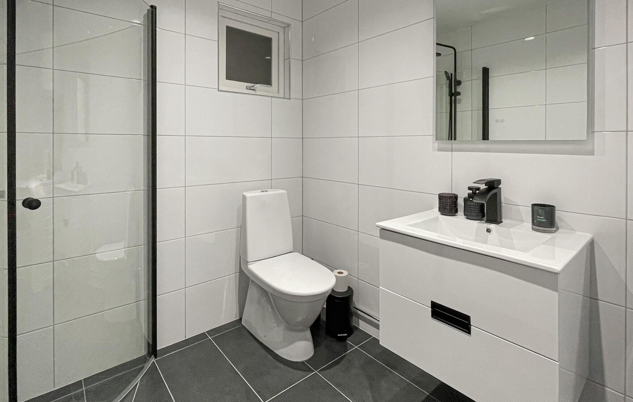 Une salle de bain moderne équipée de toilettes, d’un lavabo et d’une douche.