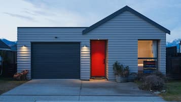A single-story house with a garage and a red door.