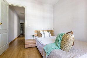 Ein Schlafzimmer mit Bett, Nachttisch und einer Tür zu einem anderen Raum.