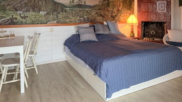 A bedroom with a bed, a desk, and chairs.