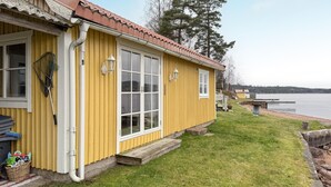 A yellow building with a red roof, a window, and a lamp post. - Stunning home in Tranås with lake view (Tranås)