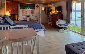 A bedroom with a bed, a chair, a table, a television, and a view of the outdoors. - Stunning home in Tranås with lake view (Tranås)