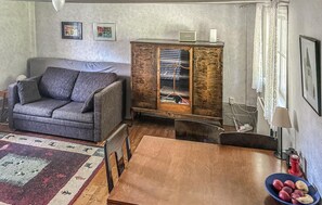 Ein Wohnzimmer mit einer Couch, einem Holzschrank und einem Esstisch.