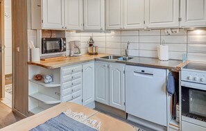 A modern kitchen with white cabinetry, a wooden countertop, a built-in oven, and a dishwasher. - Gorgeous apartment in Alingsås with WiFi (Alingsås)