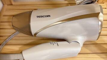 A hair dryer on a wooden shelf with a sign indicating no smoking.