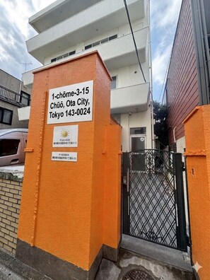 A building entrance with a sign indicating the address and contact information.