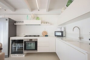 Eine kompakte Küche mit integriertem Kühlschrank, Backofen, Mikrowelle und einem Gasherd.