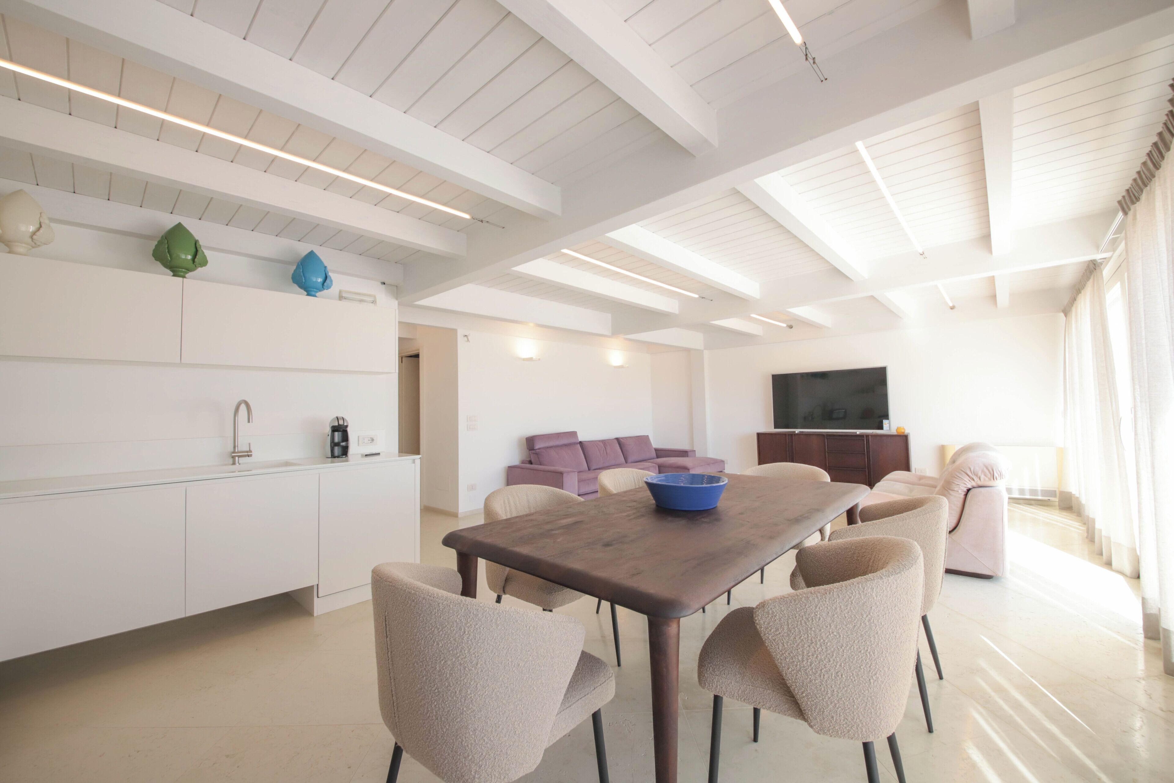 Un espace de vie moderne comprenant une cuisine, un coin repas et un espace détente.