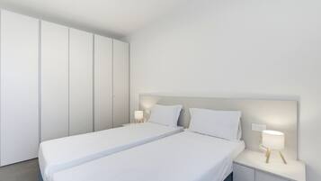 Ein modernes Schlafzimmer mit einem großen Bett, zwei Nachttischen und einem Kleiderschrank.
