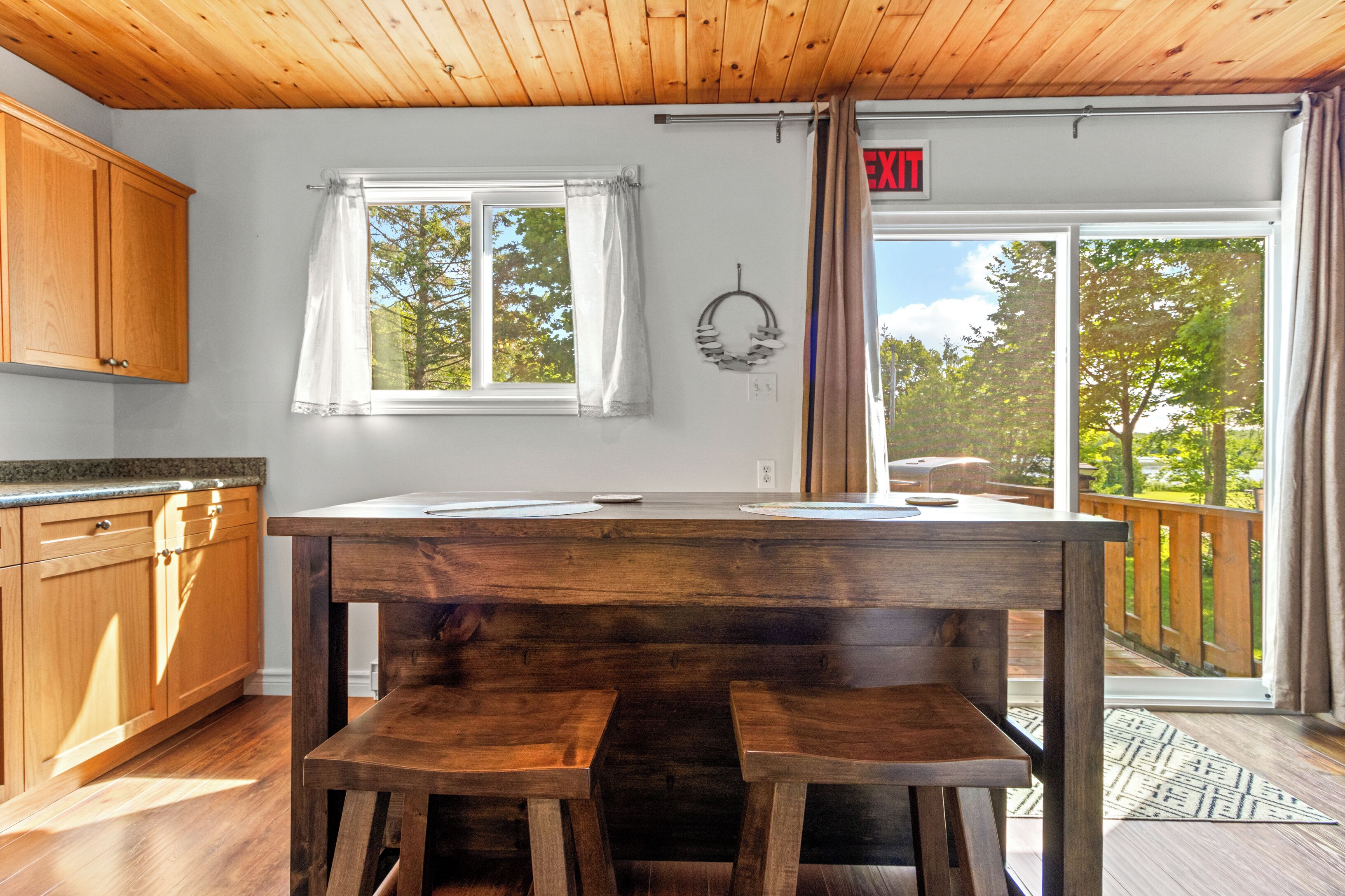 Une cuisine avec des meubles de rangement en bois, une table en bois et un banc.